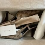 Elegant Gucci heels with iconic logo pattern elegantly boxed for stylish presentation